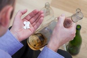 Man mixing pills with alcohol