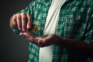 Man dumping pills into his hand