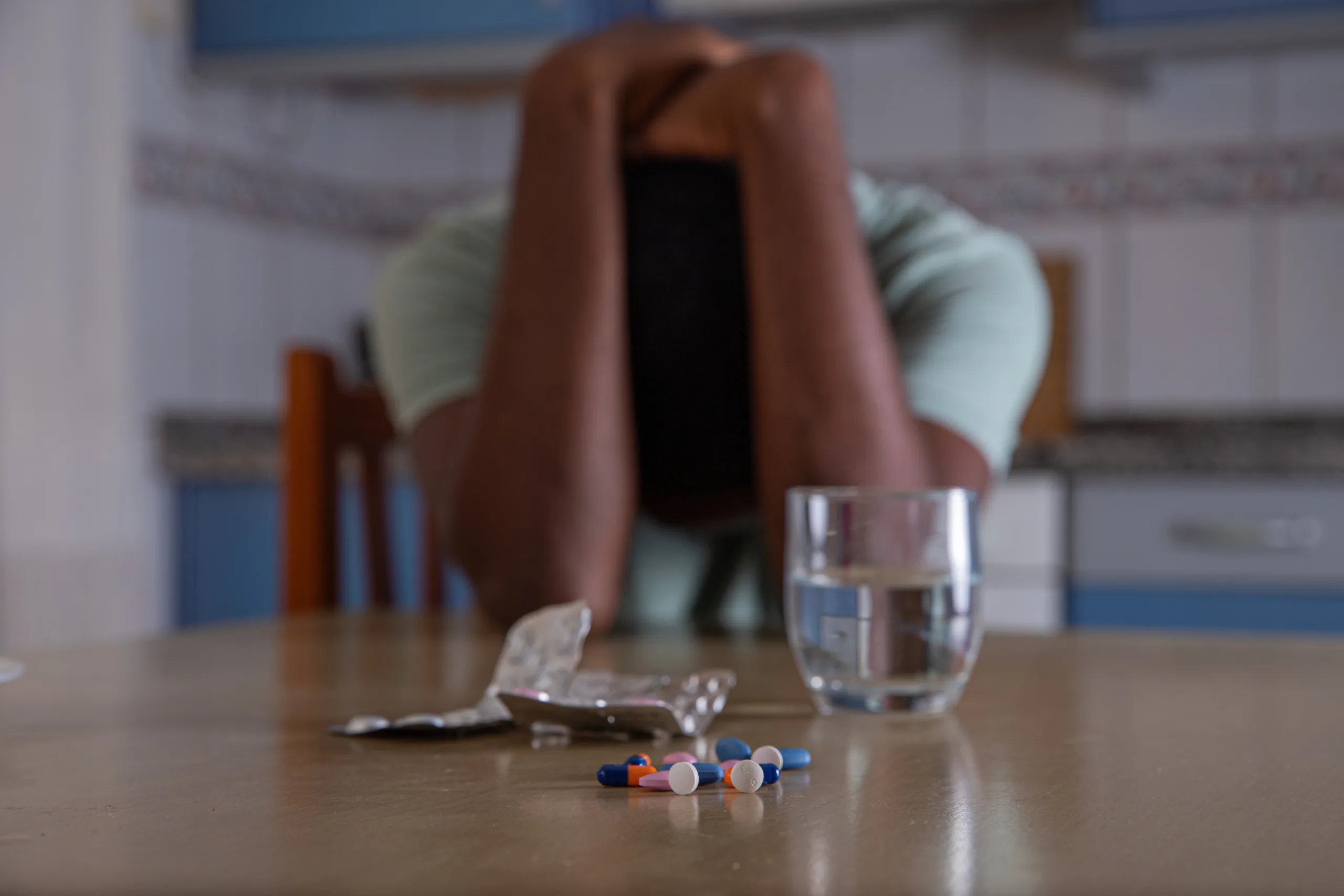 Desperate man with his head down takes psychiatric drugs to treat depression. Psychiatric pills